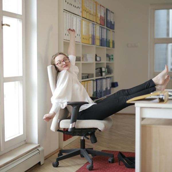 A person balancing on one leg in a modern, bright room.